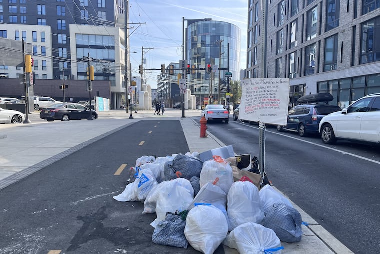 Residents of the North Liberty Triangle development pile their trash on a sidewalk in front of a bike lane daily, sparking anger from residents who live nearby, particularly those who live at the complex across the street, 1115 Germantown Ave. Residents have erected a sign.