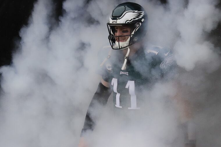 Eagles quarterback Carson Wentz walks through the smoke during player introductions before the Eagles played the Indianapolis Colts on Sunday, September 23, 2018 in Philadelphia. YONG KIM / Staff Photographer