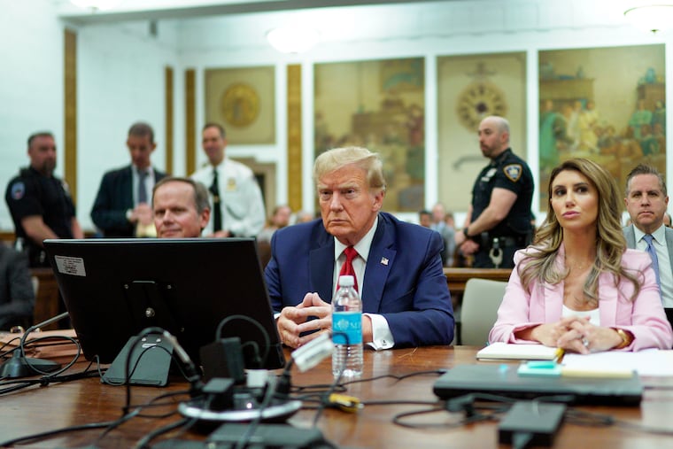 Former President Donald Trump, center, sits at the defense table with his attorney's Christopher Kise, left, and Alina Habba, at New York Supreme Court.