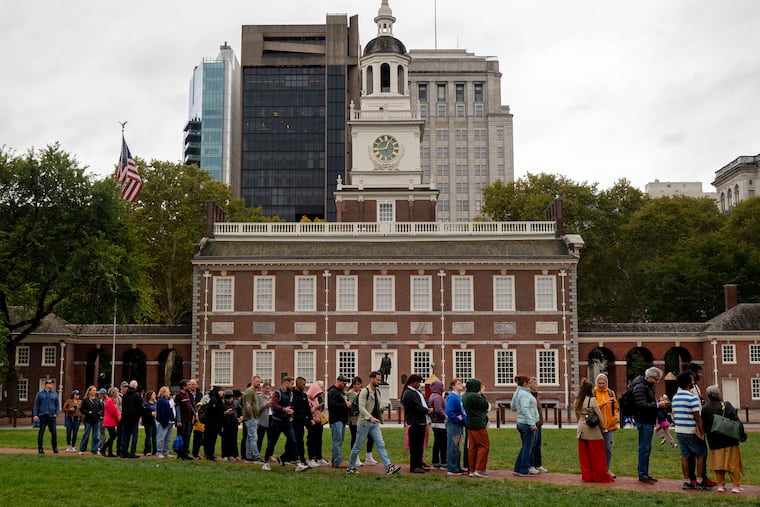Visitors stand in a long line in front of Independence Hall waiting to view the Liberty Bell through a window in the Liberty Bell Center in Independence National Historical Park Sunday, Oct. 12, 2025 as the building is closed while the shutdown of the federal government continues.