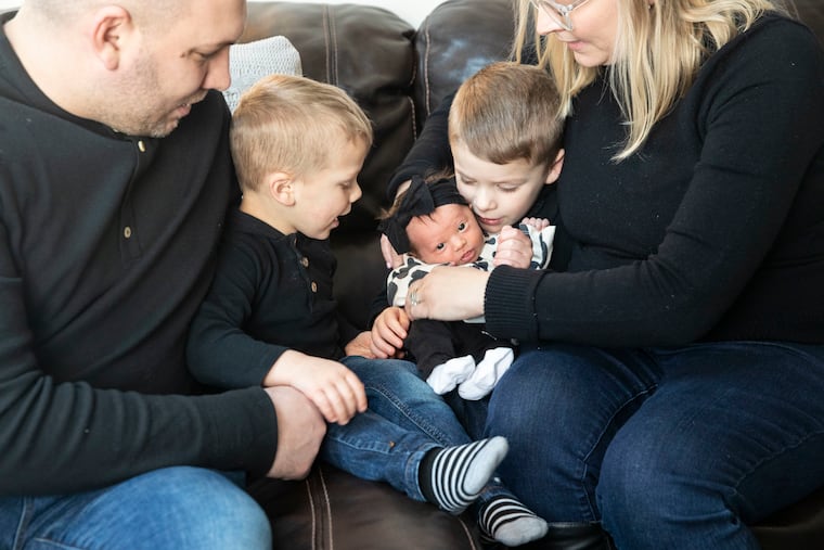 George, Benny, 3, Aliza, 8 days, Georgie, 4, and Christine Steffon gather on the couch for a portrait at their home in Levittown on Tuesday.