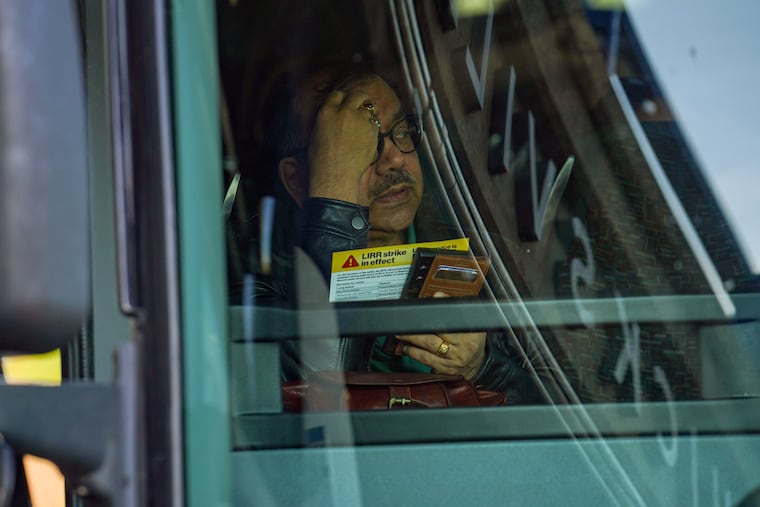 With an informational bruchure in hand, a commuter boards a shuttle bus at the Long Island Rail Road station in Hicksville, N.Y., on Monday morning, May 18, 2026. A strike on the LIRR, America’s busiest passenger rail service, upended the commutes of more than a quarter-million riders on Monday who rely on the service to get to work.