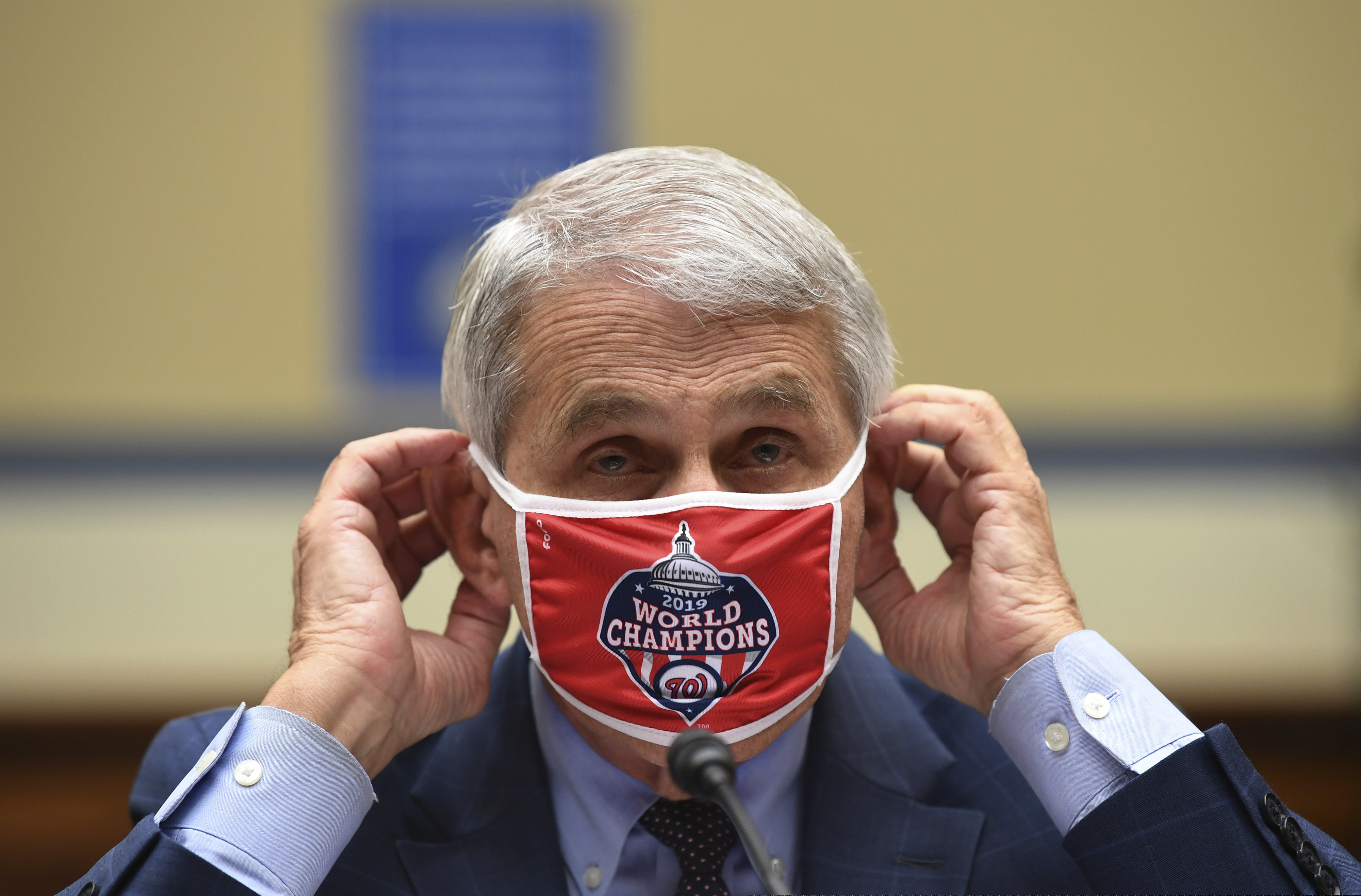 Dr. Anthony Fauci, director of the National Institute for Allergy and Infectious Diseases, adjusts his Washington Nationals face mask during the House session Friday.