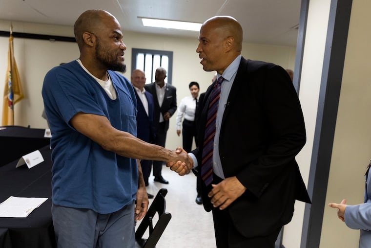Lamon Hill greets Sen. Cory Booker (right) during a roundtable at the Camden County Correctional Facility in Camden on Monday, Aug. 28, 2023. Booker introduced a new bill that would allow states to use Medicaid to pay for the care of inmates. For people with addiction, leaving jail can be deadly because the forced period of abstinence lowers their tolerance for drugs, putting them at risk of an overdose. In Camden, jail officials have worked for some time to offer better medical care for inmates with addiction.