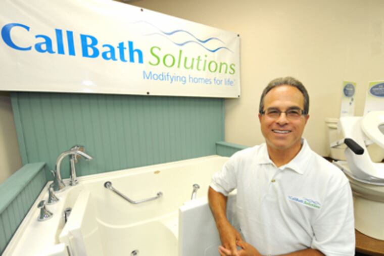 Stephen Klein, president of Anthony Home Improvements, with a walk-in tub and a specialized toilet that capture the aging boomer market. The business that started as Anthony, the Family Plumber has had to adapt to the economy. (Clem Murray / Staff Photographer)