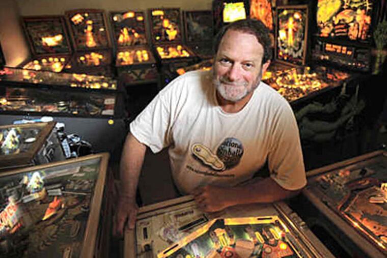 David Silverman stands amid some of his pinball collection. "Even as a kid, I was fascinated," he says of the machines. "I can remember, as a child, looking at the letters, at the artwork, at the flashing lights." (ALGERINA PERNA / Baltimore Sun)
