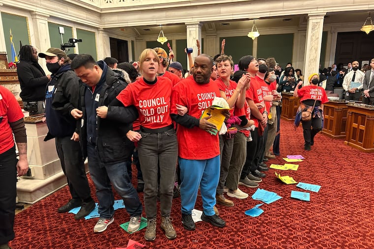 Several dozen protesters locked arms on the City Council floor Thursday ahead of a final vote on the Sixers' proposed arena in Center City.