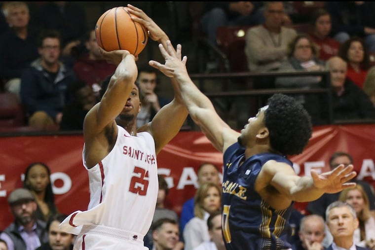 Saint Joseph's James Demery (25) shoots past La Salle's Pookie Powell (0) during a game at Hagan Arena on Saturday, March 3, 2018. Saint Joseph's won 78-70. TIM TAI / Staff Photographer