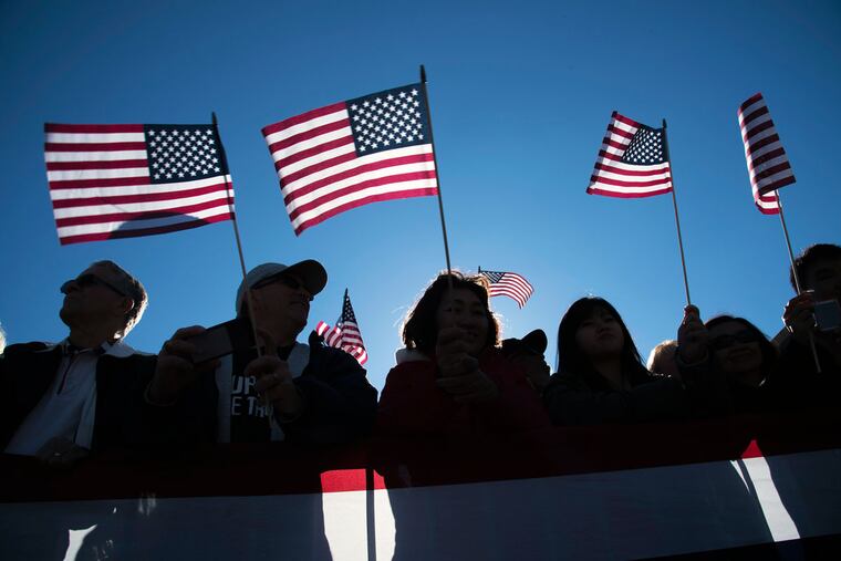 Lots of spectators in the crowd along Market Street waved miniature American flags during Philadelphia's first Veterans Day parade Nov. 8, 2015.