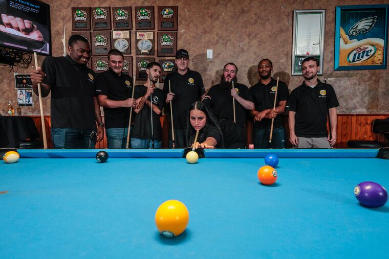 #LepLife, a team of seven guys and one woman from the Crazy Leprechaun bar in Port Richmond, just became the American Poolplayers Association's World 9-Ball Champions. Starchelle Goris lines up a shot. Behind her are (from left) Nasir Blanden, Jason O'Hara, Mike Saleh, Sonny Johnson, Mike Quinn, Iyasu Watts, and John Perzel.