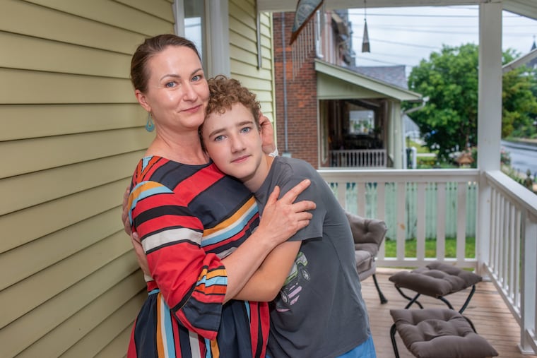 Veronika Pavliutina (left) and her son Yegor, 12, on the porch of their home in Perkasie. She and her children will depart the U.S. for Italy next month. The family came to Philadelphia amid the Russian attack on their Ukrainian homeland and home city of Odesa.