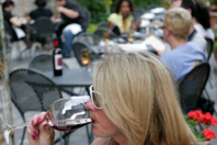 Susan Gallagher enjoys a glass of wine at one of the garden tables at Osteria, Marc Vetri's new spot at 640 North Broad St.