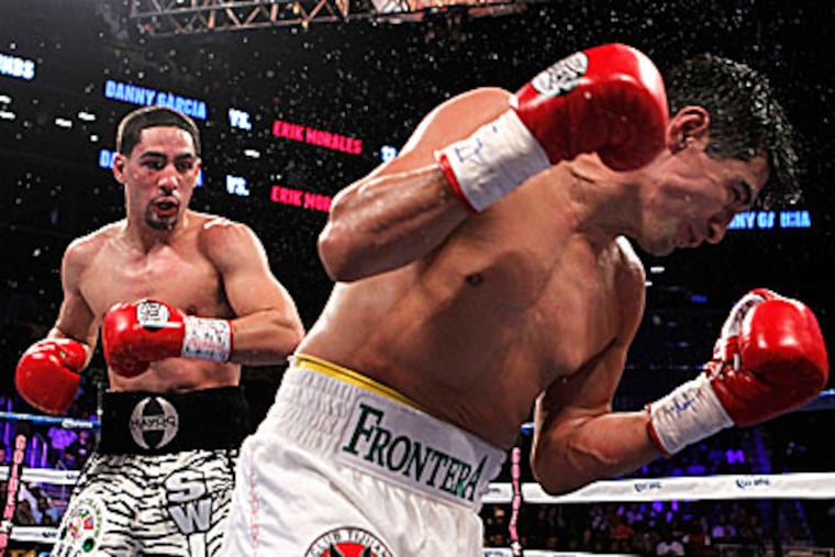 Danny Garcia (left) defended his titles with a fourth-round knockout of Erik Morales on Saturday night. (Jason DeCrow/AP)