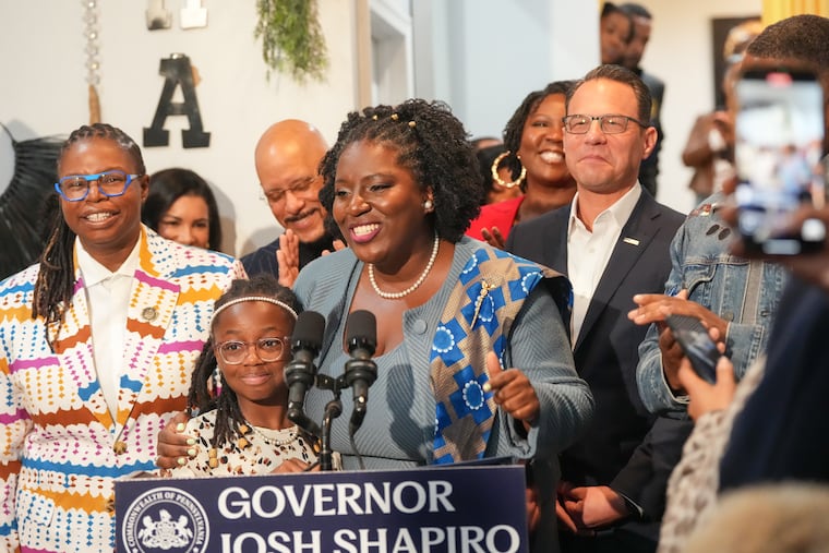 Pa. House Speaker Joanna McClinton, center, stands with Lorel Banfield, front left, and state Rep. La'Tasha D. Mayes, back left, of Allegheny County, and Gov. Josh Shapiro, back right, at an event Island Design Natural Hair Studio, in West Philadelphia, where Shapiro signed the CROWN Act.