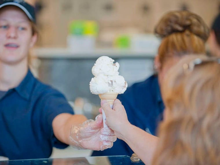 Student serves cone at Berkey Creamery, Penn State. (Penn State photo)