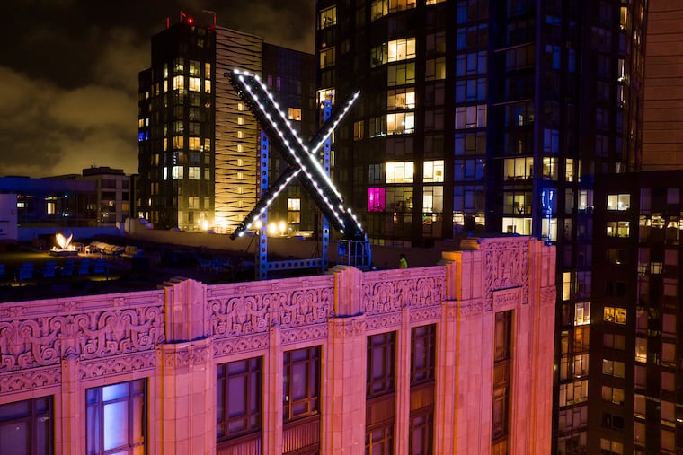 FILE - Workers install lighting on an "X" sign atop the company headquarters, formerly known as Twitter, in downtown San Francisco, July 28, 2023. (AP Photo/Noah Berger, File)