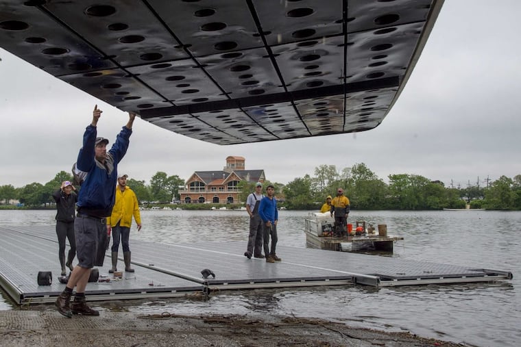 Workers unload docks into the Cooper River after transporting them from the Schuylkill on Wednesday. The Stotesbury Cup Regatta, the largest high school rowing regatta in the world, was forced by river conditions to move from Philadelphia to New Jersey.