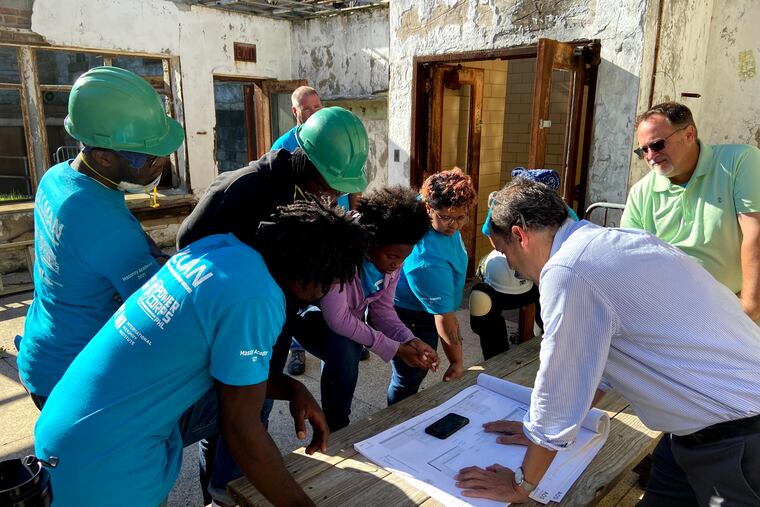 Students at Eastern State Penitentiary's masonry academy review plans with the design team.