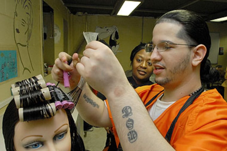 At the Camden County jail, a beautician turned corrections officer, Jackie Wescott, teaches inmate and student Jose Rodriguez to style hair. (April Saul / Staff Photographer)