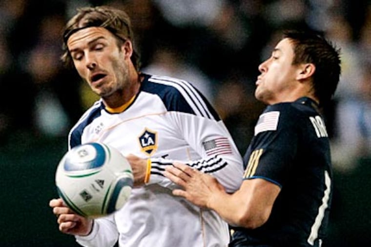 Galaxy midfielder David Beckham battle for the ball with Union midfielder Kyle Nakazawa. (Bret Hartman/AP Photo)