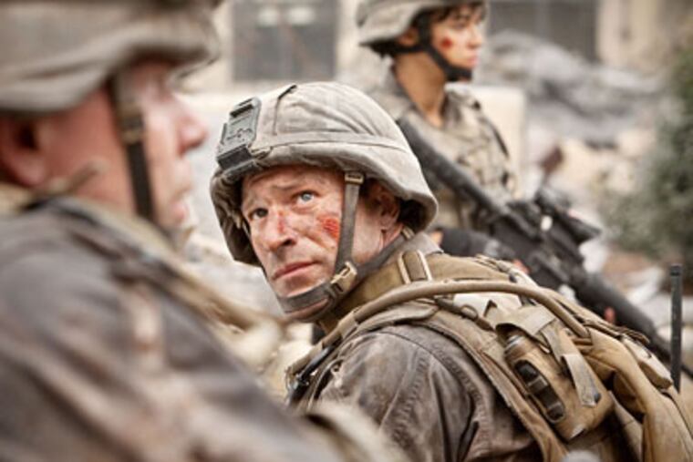 Aaron Eckhart and Michelle Rodriguez (background) play Marines fighting aliens from space.