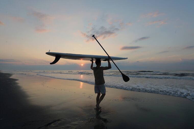 Nikolas Pattantyus searches for dolphins off the 109th Street beach of Stone Harbor with his paddle board.