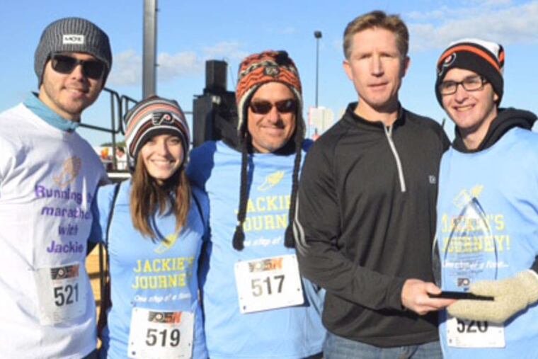 Flyers coach Dave Hakstol (center) presents Jackie Lithgow with the team's 7th Man Award to recognize his overcoming adversity.