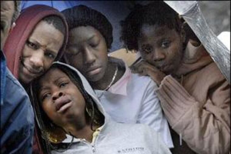 Grief-stricken friends watch Damien Floyd’s body lowered into the grave. Killed Dec. 6 in North Philadelphia, he is among the most recent young victims. He was 17.