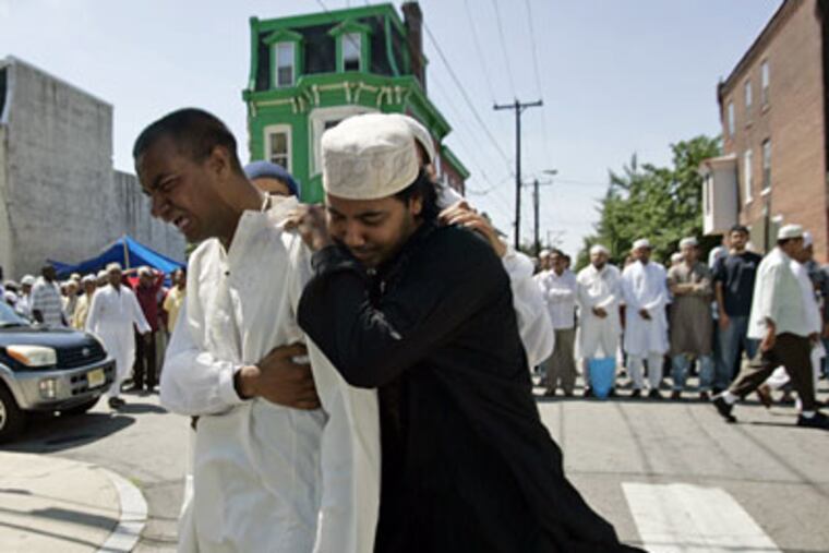 Friends and family reacting after viewing the body of Fakhur Uddin during a service held on 43rd Street in Philadelphia. (Michael Perez/Inquirer)