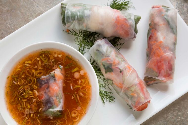 Filled with brilliantly hued garden vegetables, colorful summer rolls are served with dipping sauce.