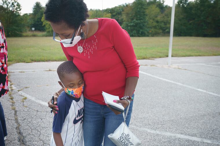 Inquirer reporter Melanie Burney receives a hug from Devon on the playground during recess, at the Paulsboro Boys & Girls Club in Paulsboro, NJ, on October 2, 2020. In Paulsboro, about 25 students come to the Boys and Girls center from 8 am. To 5 p.m. to do their school work remotely. About 10 or so don’t have chromebooks so they share devices to attend classes and work independently.
