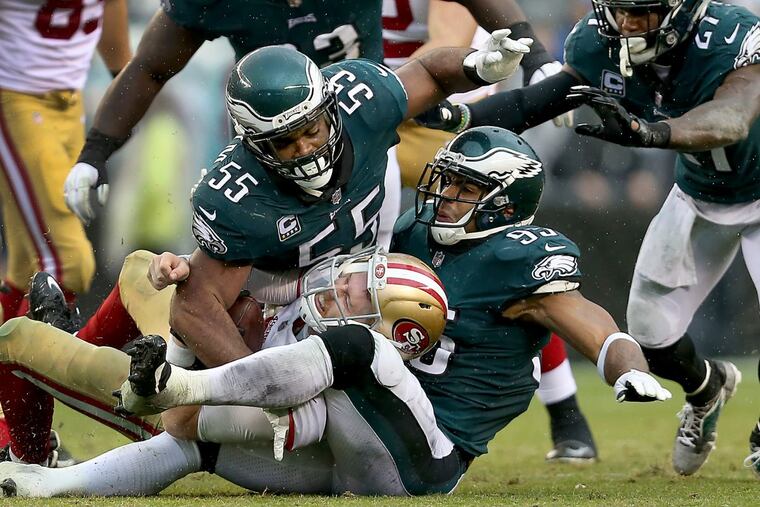 Eagles Brandon Graham, left, and Mychal Kendricks, right, stop 49ers quarterback C.J. Beathard on Sunday.