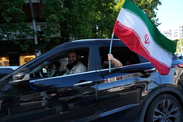 A child holds an Iranian flag through the window of a vehicle in northern Tehran, Iran, Friday, May 1, 2026.