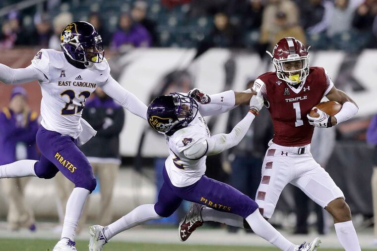 Temple's Ventell Bryant shoves off East Carolina's Devon Sutton while linebacker Terrell Richardson chases Bryant. YONG KIM/Staff Photographer