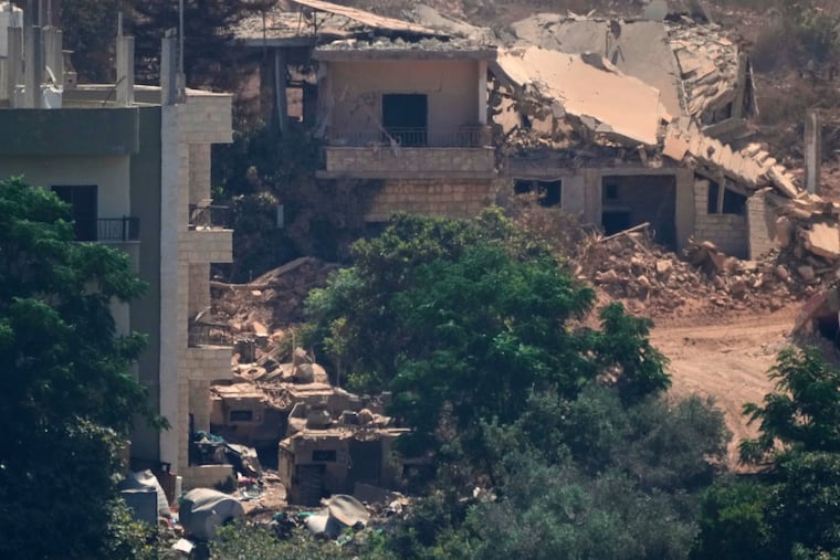 Israeli military vehicles, left, are seen stationed among homes in the village of Zawtar al-Sharqiyah, occupied by Israeli forces, is seen from the southern village of Zawtar al-Gharbieh, Lebanon, Wednesday, Aug. 5, 2026.
