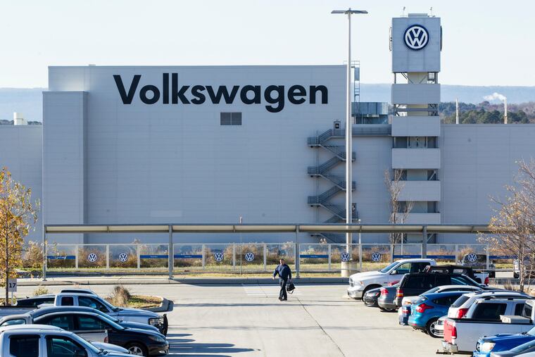 FILE - In this Dec. 4, 2015, file photo, a man walks through the employee parking lot at the Volkswagen plant in Chattanooga, Tenn.