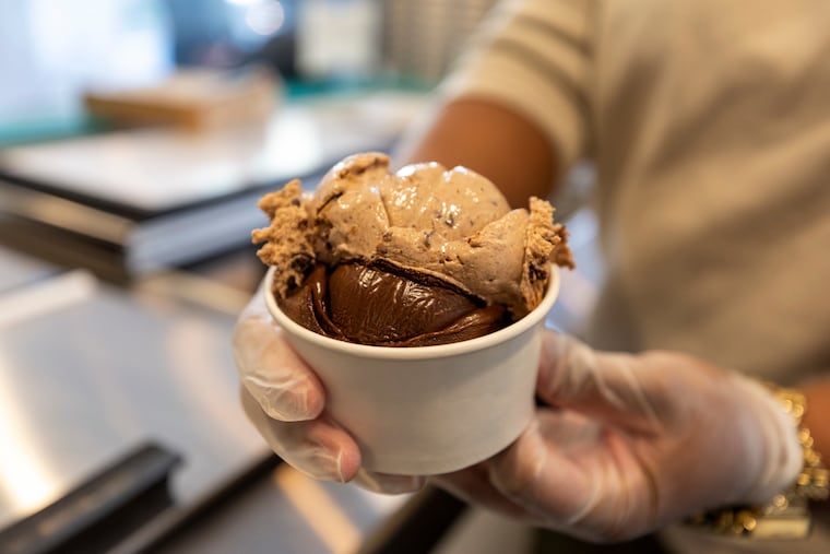 Ahmira Saunders, 22, of North Philadelphia, Pa., is scooping a Rich Chocolate Sorbet and a Double Chocolate Peanut butter Chunk in a cup at Zsa’s in Philadelphia, Pa., on Friday, Jan. 17, 2025. Saunders has worked here for 3 years. “It was really shocking and I understand the reasons why of closing,” Saunders said. “I’m going to miss my coworkers and the ice cream.”