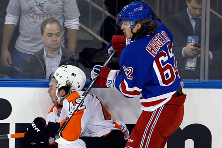 Jason Akeson falls down along the boards against the Rangers' Carl Hagelin. (Yong Kim/Staff Photographer)