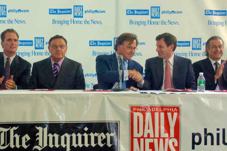 Brian P. Tierney (center) shakes hands with then-publisher Joe Natoli after Philadelphia Media Holdings completed the purchase of The Inquirer, the Daily News and Philly.com from the McClatchy Co. Other PMH investors include (from left) Michael J. Hagan, William A. Graham IV, and Ian Berg of ETF Venture Funds.