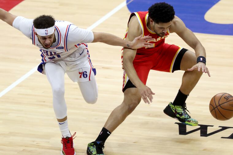Sixer Seth Curry (left) and Atlanta Hawk Skylar Mays going after a loose ball on Wednesday.