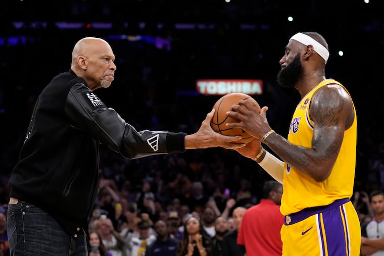 Kareem Abdul-Jabbar, left, hands the ball to Los Angeles Lakers forward LeBron James after passing Abdul-Jabbar to become the NBA's all-time leading scorer during the second half of an NBA basketball game against the Oklahoma City Thunder Tuesday, Feb. 7, 2023, in Los Angeles. (AP Photo/Ashley Landis)