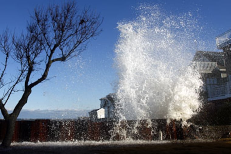 Waves crash against a retaining wall behind a house on Seaview Ave. in Strathmere. The wall was recently erected, one of the stop gap measures being used to try to strengthen the eroding shore line there. (Eric Mencher / Staff Photographer)