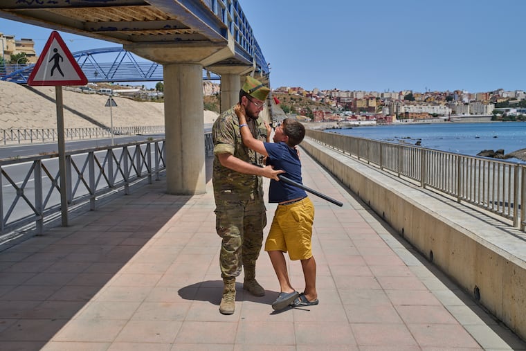 A 12-year-old unaccompanied minor who crossed into Spain is escorted by a Spanish soldier to the Spain-Morocco border as the child begs not to be sent back to Morocco from the Spanish enclave of Ceuta, Monday, Aug. 3, 2026. The forced deportation of the unaccompanied minor was stopped by a high-ranking official a few yards before the child reached the border after residents and journalists said the migrant was a minor.