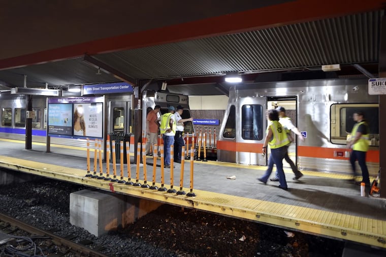 SEPTA officials look over the damaged train cars at the 69th Street Transportation Center.