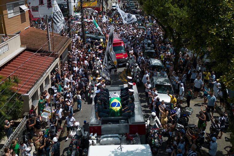 The casket of late Brazilian soccer great Pelé is draped in the Brazilian and Santos FC soccer club flags as his remains are transported from Vila Belmiro stadium, where he laid in state, to the cemetery during his funeral procession in Santos, Brazil, Tuesday, Jan. 3, 2023.