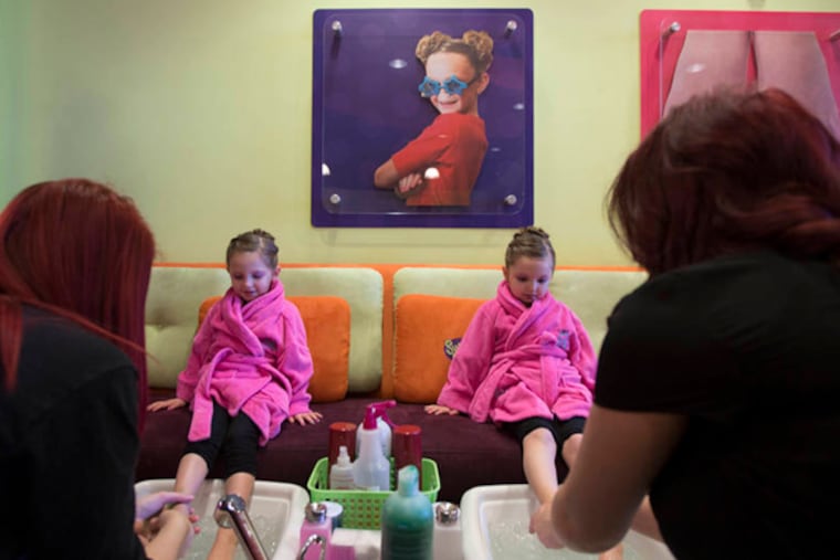 At Sweet & Sassy in Cherry Hill, 4-year-old twins Giuliana (left) and Angelina Roach dip their feet in a pedicure bath.