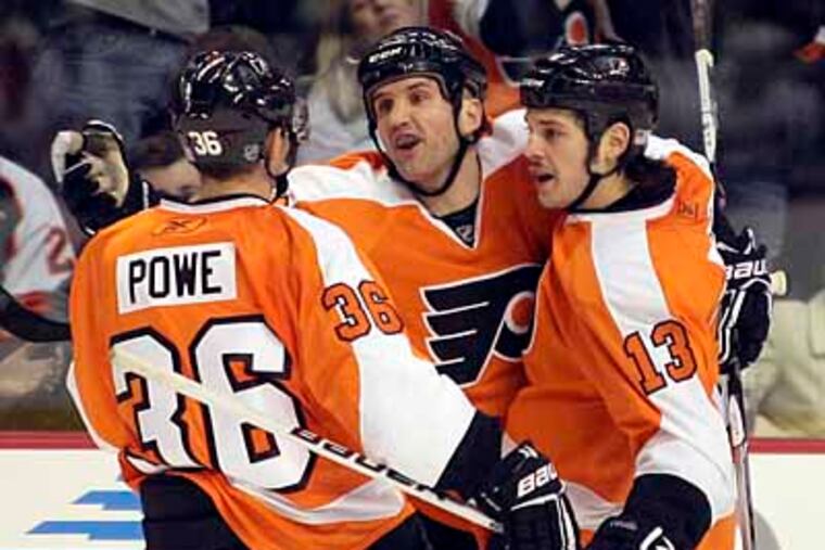 Flyers' Ian Laperriere (center) celebrates a goal with teammates Darroll Powe (left) and Dan Carcillo. (Yong Kim / Staff Photographer)