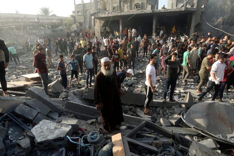 Palestinians look for survivors following an Israeli airstrike in Khan Younis refugee camp, southern Gaza Strip, on Tuesday, Nov. 7, 2023.