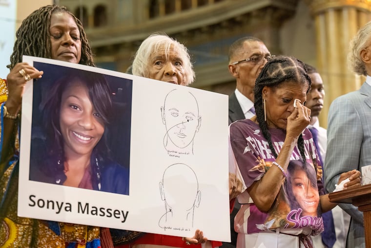 Donna Massey (center right) wipes tears from her face as she listens to Rev. Al Sharpton speak during a July 2024 press conference at New Mount Pilgrim Church in Chicago over the shooting death of her daughter, Sonya.
