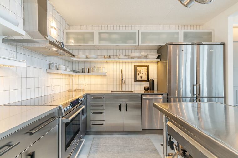 The kitchen has stainless steel appliances, including side-by-side refrigerators.